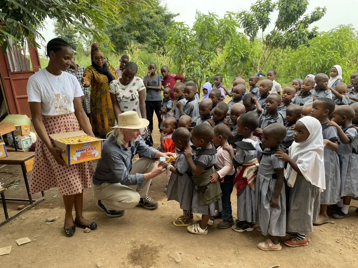 Children, staff and a visitor gathered beneath trees at the Centre