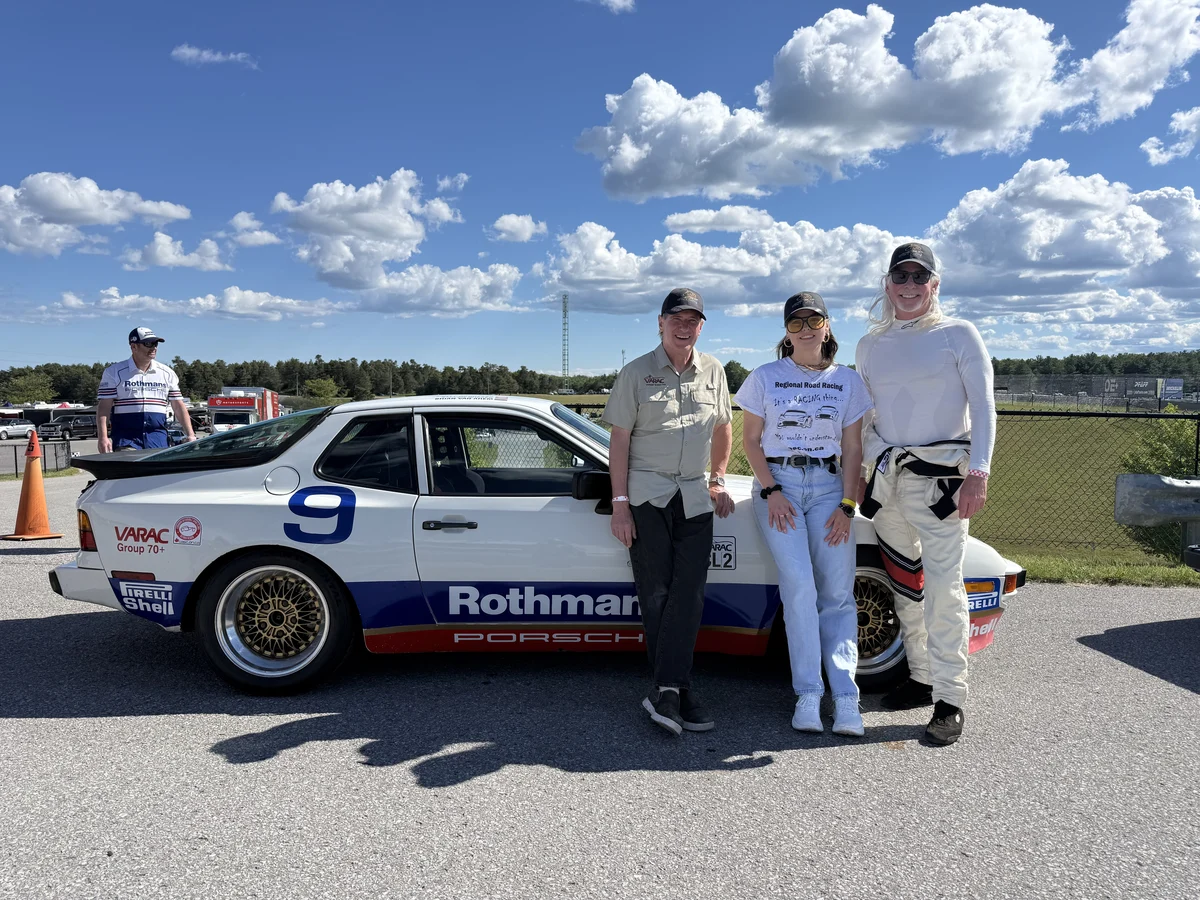 Three people beside the white number 9 Porsche